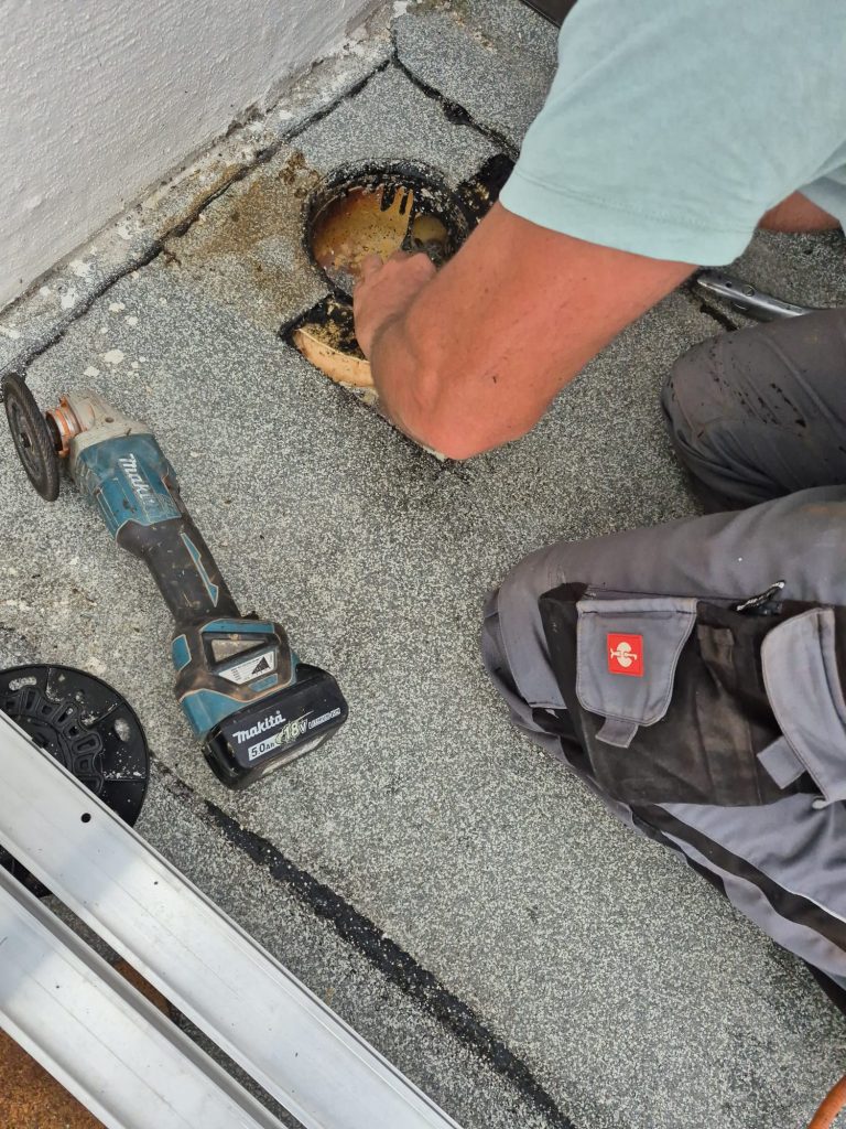 Reparatur und Beseitigung kleiner Risse und Leckagen bei der jährlichen Inspektion des Flachdachs des Gebäudes.